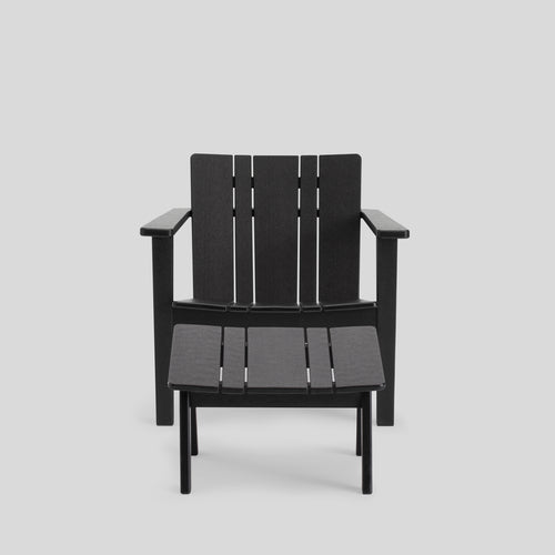 A studio photo of Low Chair Black / Chair + Ottoman