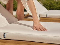 A woman pressing her hand into a soft Neighbor sun lounger seat cushion